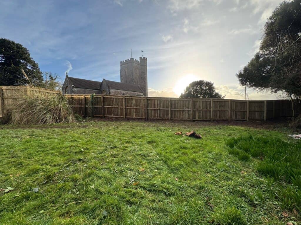 Scenic view of a historic castle with a grassy garden in the foreground.