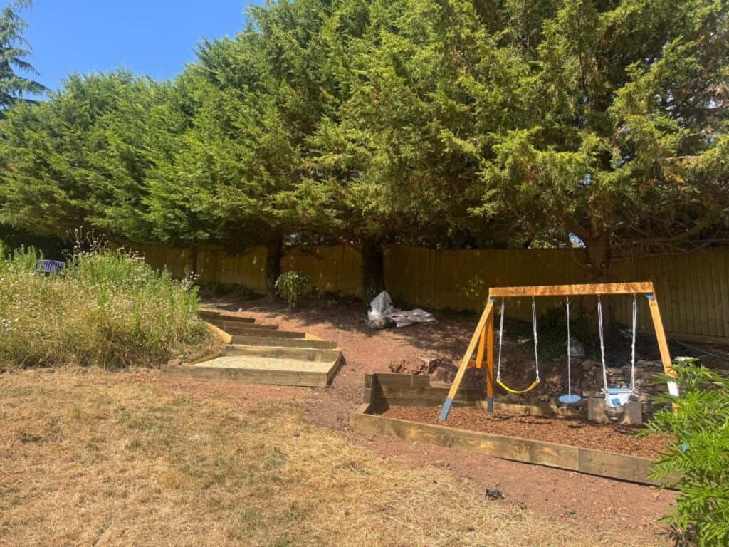 Garden with new landscaping and children's swing set in Devon.