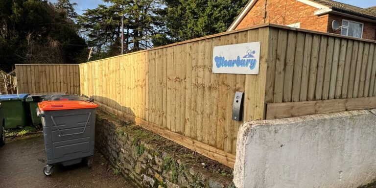 Devon Trees & Grounds Ltd sign on a wooden fence in Devon.