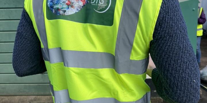 Person wearing high-visibility vest with 'Dawlish Against Plastic' logo.