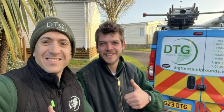 Devon Trees & Grounds Ltd team with service vehicle in a garden setting.